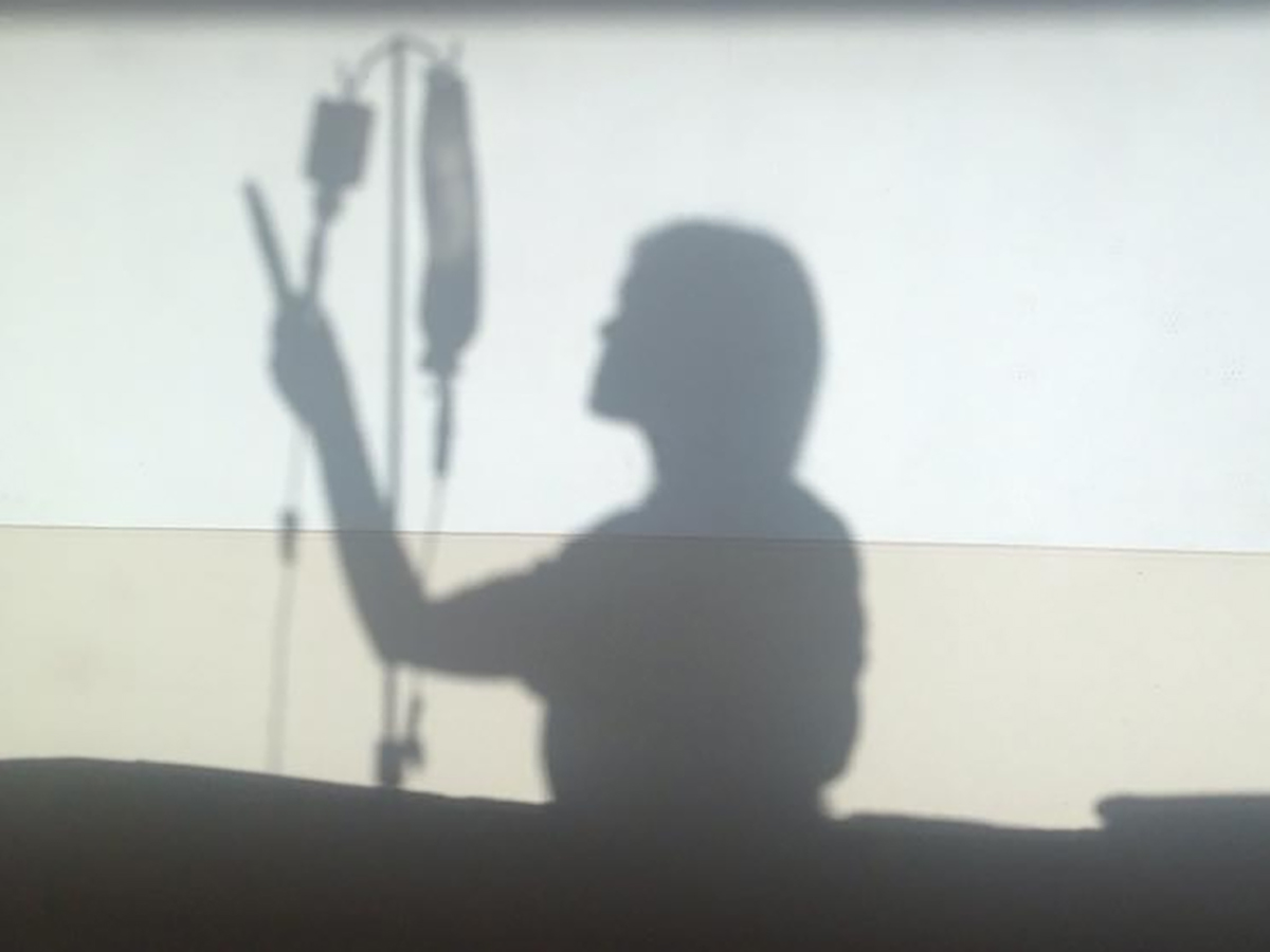 Silueta de una enfermera preparando la administración de un suero